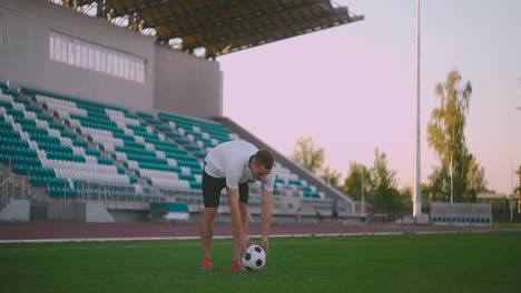 Stellen-Sie-Den-Fußball-Auf-Die-Rasenbahn-Und-Schlagen-Sie-Den-Ball-Im-Stadion-Mit-Grünem-Rasen.-Ein-Professioneller-Fußballspieler-Kickt-Den-Ball-In-Zeitlupe